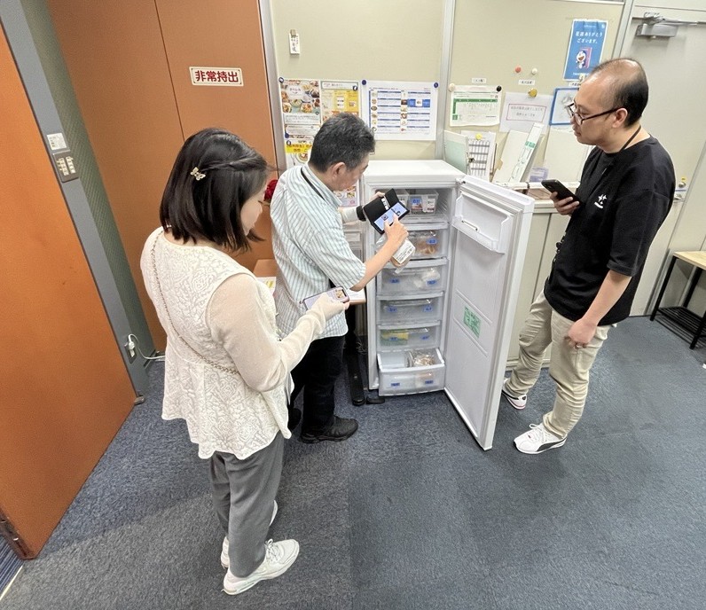タベレルの冷凍庫前で商品を選ぶ社員の様子